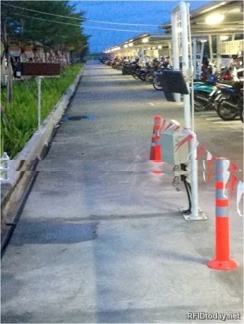 ช่องทางวิ่งเฉพาะสำหรับรถมอเตอร์ไซค์ มีเสาอากาศ RFID และตู้ควบคุมติดตั้งข้างทาง ถัดไปเป็นลานจอดรถมอเตอร์ไซค์ของพนักงาน